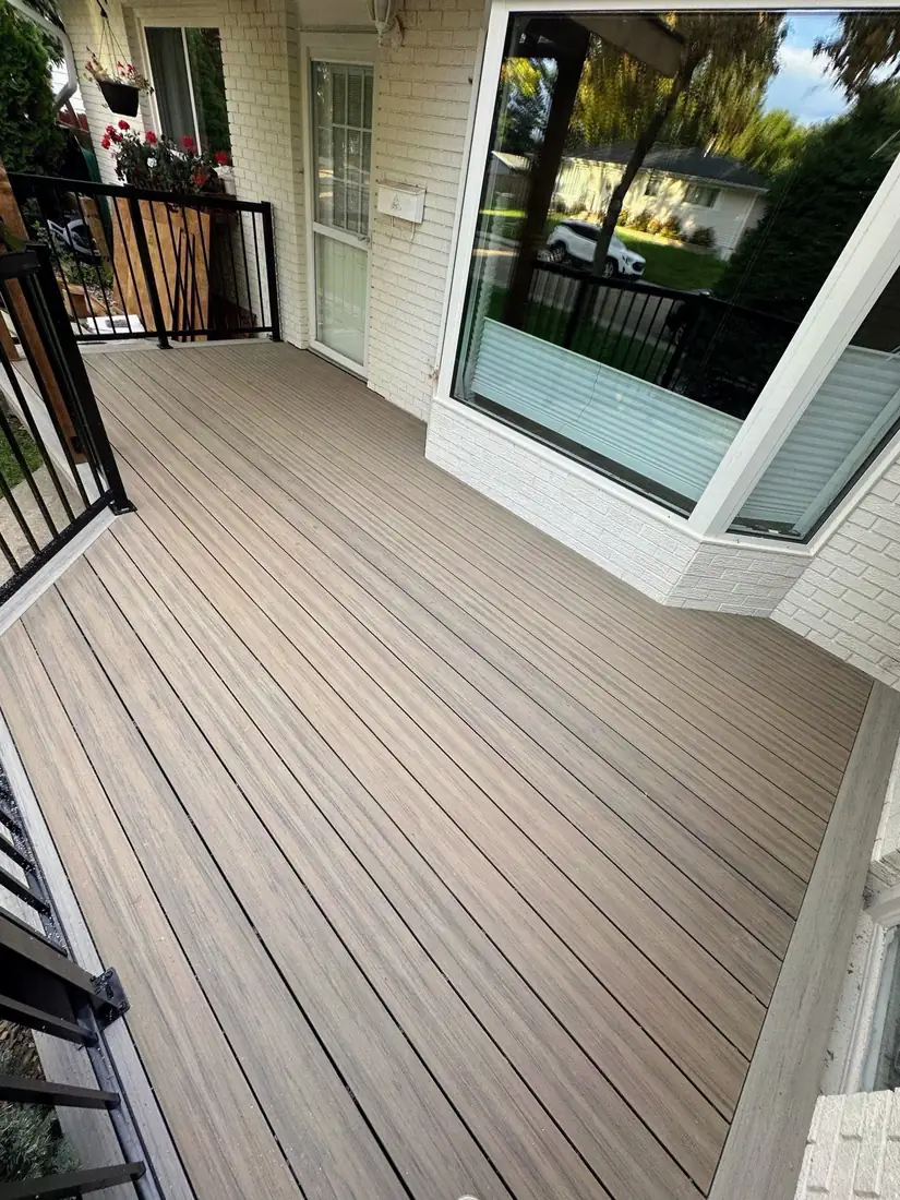 Brown composite front deck with picture-frame border along a brick home, Edmonton — TrueBlue Builders Ltd